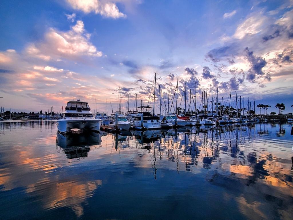 Shelter Cove Marina yachts reflected in calm water beneath a blue and pink evening sky