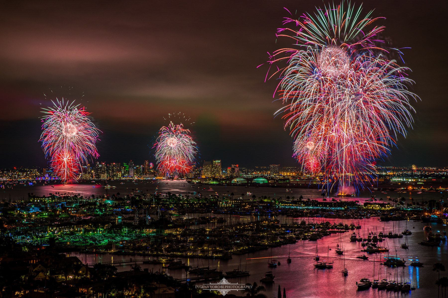 Fireworks over San Diego Bay with downtown San Diego illuminated in the distance